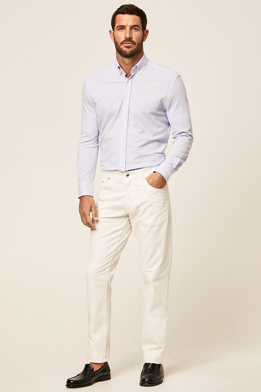 Men's off white jeans, tucked in pale lilac dress shirt and black leather penny loafers worn sockless outfit