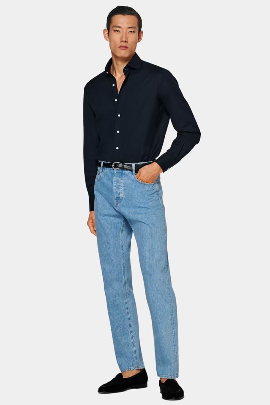 Men's light wash jeans, tucked in navy dress shirt, black leather belt and black suede Belgian loafers outfit