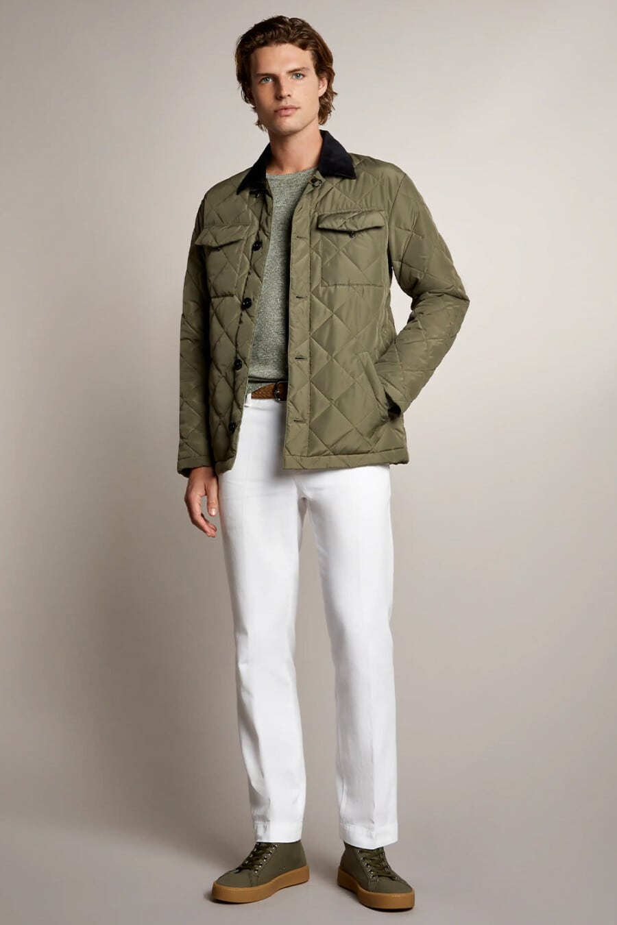 Men's white jeans, green T-shirt, green quilted jacket and green high-top gum sole sneakers outfit