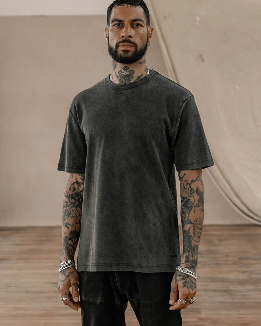 Men's T-shirt trends - man wearing a black heavyweight washed tee with black jeans